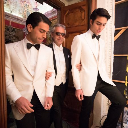 Andrea Bocelli walks with his two sons Amos and Matteo on either side at the SR45th Anniversary fashion show.