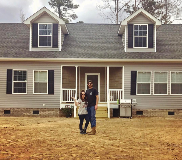 jenella and david standing infront of their new home 