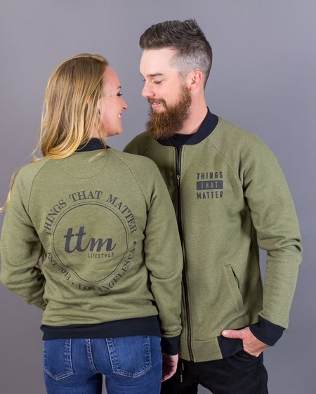Maci Bookout and husband Taylor McKinney standing face to face smiling for promotion of their fashion line.