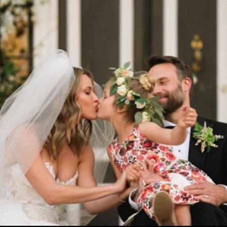 At their wedding: Jill Wagner kissing her to-be step-daughter, Lija, as she is carried by David Lemanowicz.