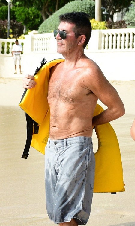 Simon Cowell in the process to wear a life jacket.