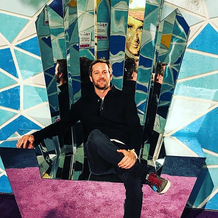 Jason Adelman sitting in a glass throne.