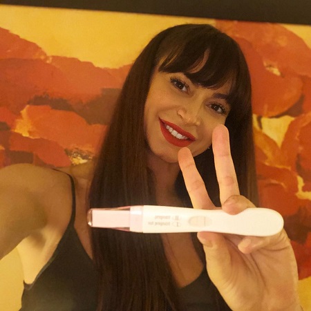 Karina Smirnoff with a pregnancy test kit announcing her pregnancy.