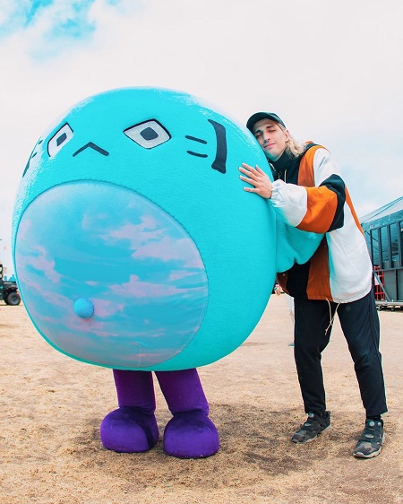 Porter Robinson hugging a guy in a blue fluffy costume.