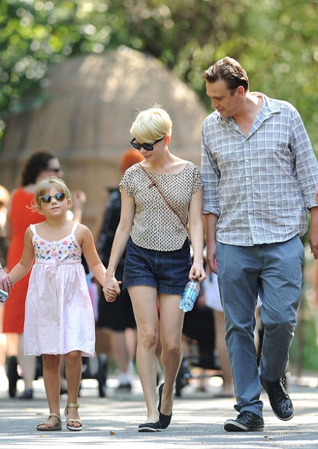 Jason Segel and Michelle Williams with her daughter holding hands.