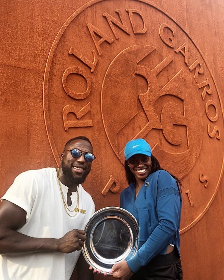 Sloane Stephens holding a tennis trophy with Jozy Altidore holding it as well.
