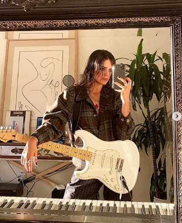 Sasha Calle is interested in playing guitar and singing song.