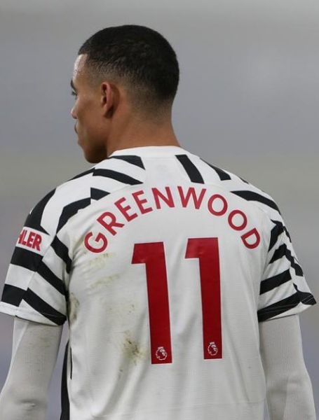 Mason Greenwood is showing his jersey.
